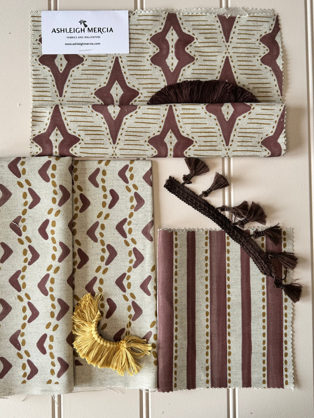 “Cosy autumn winter living room styled with rich coloured soft furnishings, including velvet cushions, a warm throw, and deep-toned curtains – seasonal home décor inspiration by Ashleigh Mercia Fabrics.”