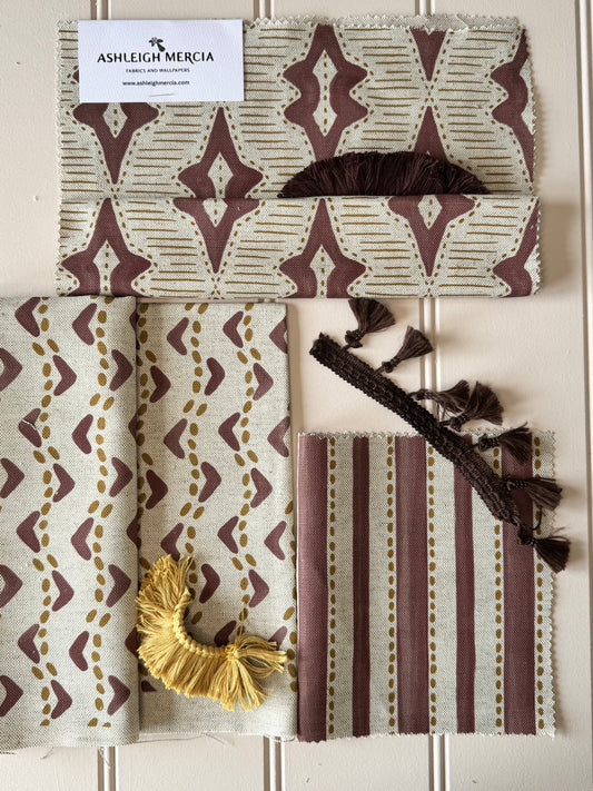 “Cosy autumn winter living room styled with rich coloured soft furnishings, including velvet cushions, a warm throw, and deep-toned curtains – seasonal home décor inspiration by Ashleigh Mercia Fabrics.”